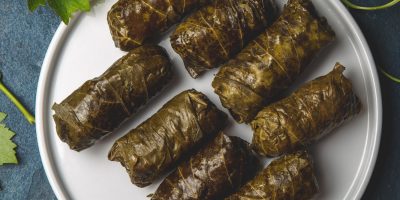 Mexican Chilean cuisine. Ninos envueltos. Grape leaves stuffed wish meat on clay plate